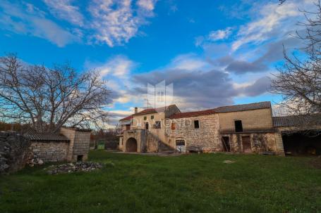 Samostojeća kamena kuća s velikom okućnicom na rubu sela
